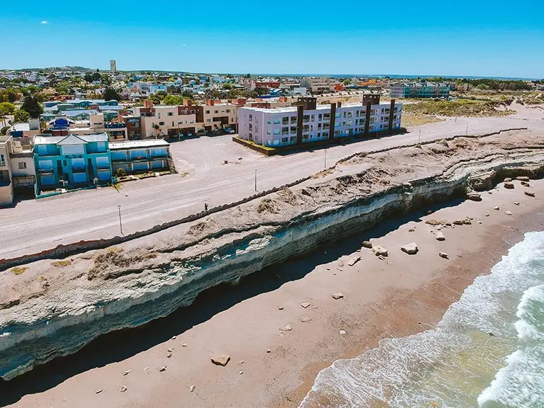 La Bajada Los Acantilados vista desde arriba, con el acantilado, la playa y las casas del barrio